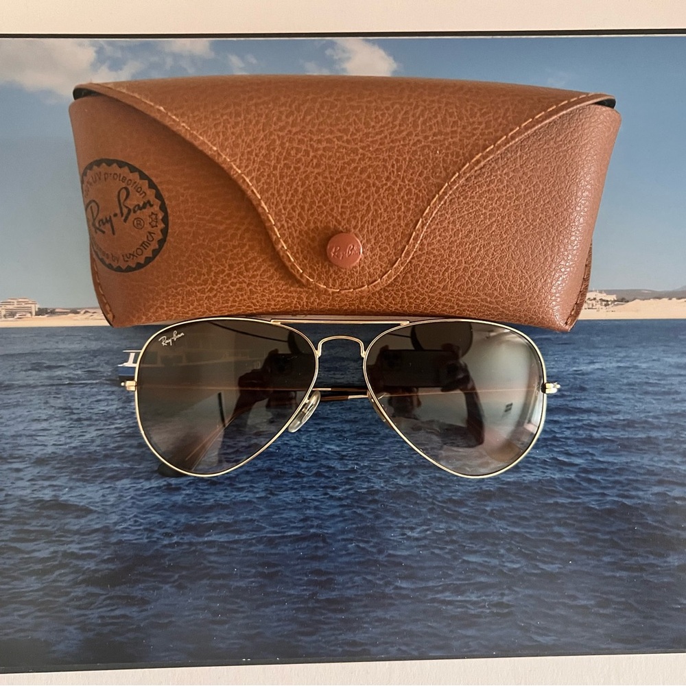 Ray Ban: Aviator style with gold metal and brown lenses.